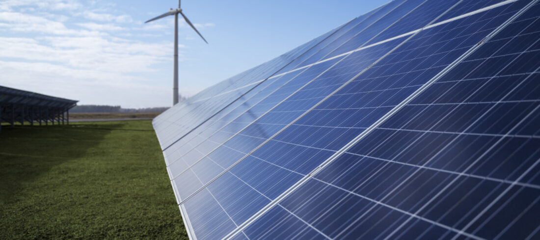 Photovoltaik Solarpark und im Hintergrund eine Windkraftanlage