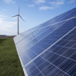 Photovoltaik Solarpark und im Hintergrund eine Windkraftanlage